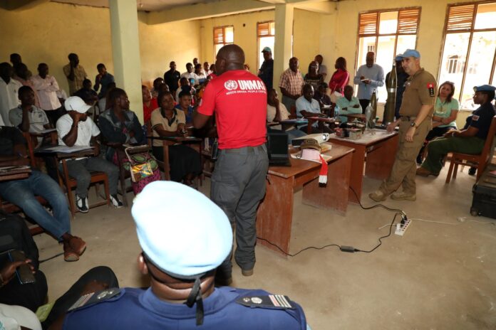 Salle de réunion sécuritaire à Kinshasa avec documents de travail sur la lutte contre les engins explosifs improvisés