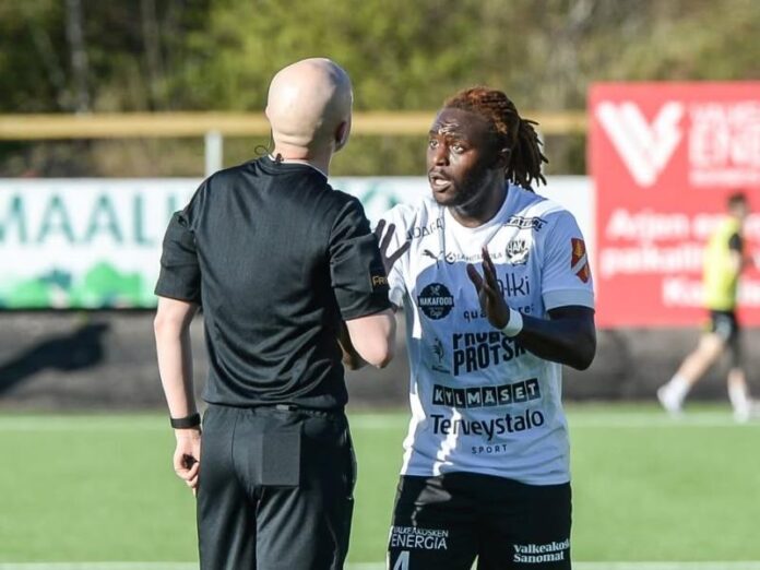 Footballeur congolais en tenue de jeu sur un terrain finlandais