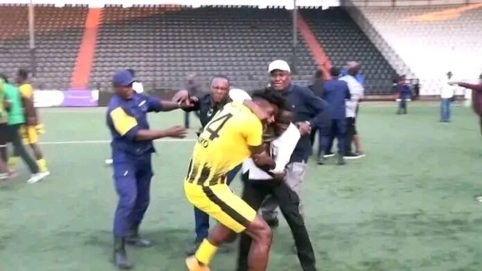 Stade de football à Lubumbashi avec joueurs et supporters en tension après un match