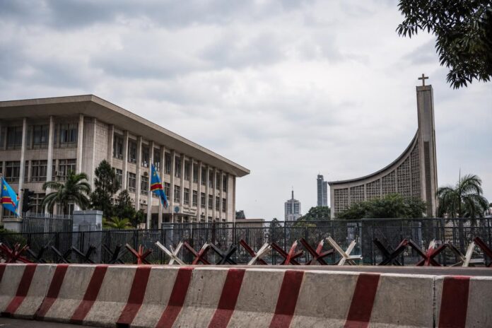 Bâtiments institutionnels à Kinshasa sous un ciel lourd symbolisant les tensions autour de la révision constitutionnelle
