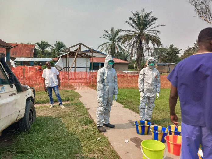 Entrée d'un centre de traitement à Mongbwalu avec zone de triage médicale et équipements de protection contre Ebola