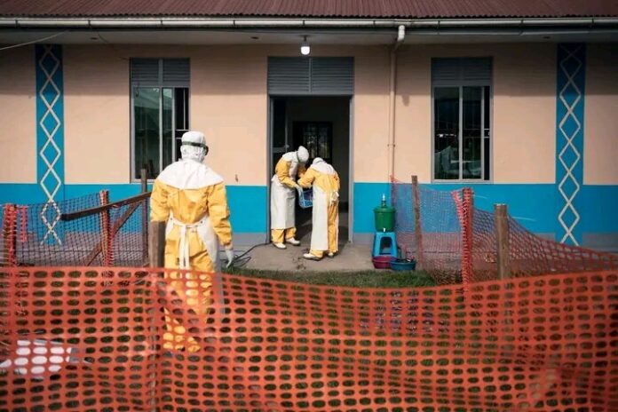 Poste de contrôle sanitaire avec lavage des mains et agents en tenue de protection à l’entrée d’une zone urbaine en RDC