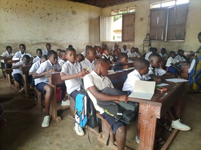 Salle d'examen vide avec des pupitres inoccupés dans une école du Nord-Kivu