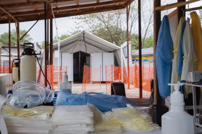 Agents de santé en tenue de protection préparant du matériel dans un centre de traitement Ebola à Bunia