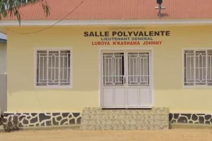 Une file de motos-taxis devant un bâtiment administratif à Bunia, Ituri, symbolisant les taxes sur la numérotation des motos