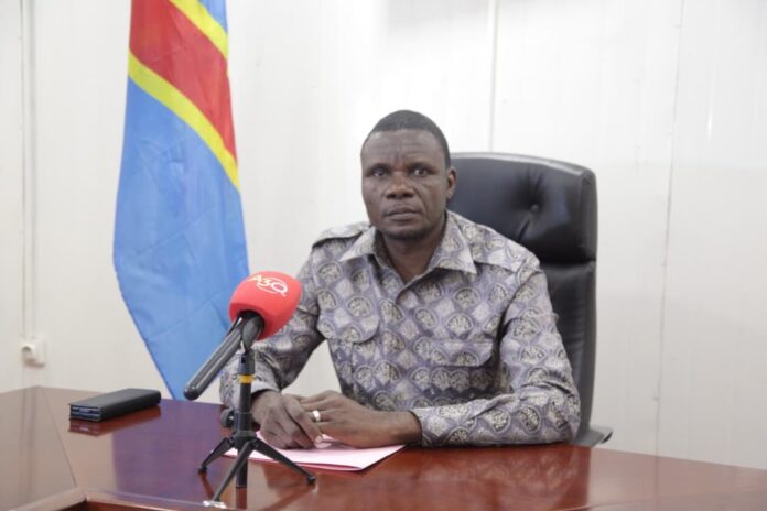 Bâtiment administratif du Fonds forestier national à Kinshasa avec documents de pétition floutés sur une table de réunion