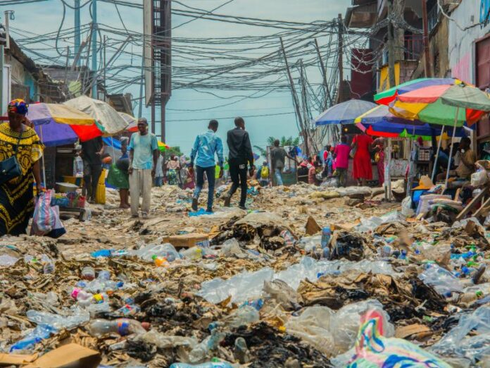 Des montagnes de déchets bloquent une rue à Kinshasa, mettant en évidence le problème d'insalubrité.
