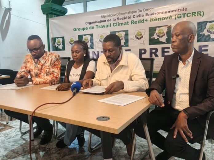 Salle de conférence à Kinshasa lors d'un point de presse sur le projet de loi du marché carbone, avec micros, documents et ambiance