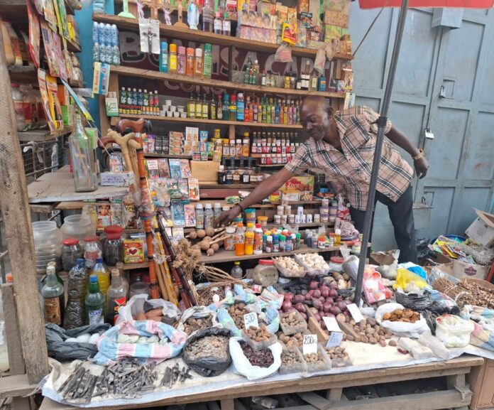 Jeunes hommes achetant des aphrodisiaques traditionnels sur un marché à Matadi