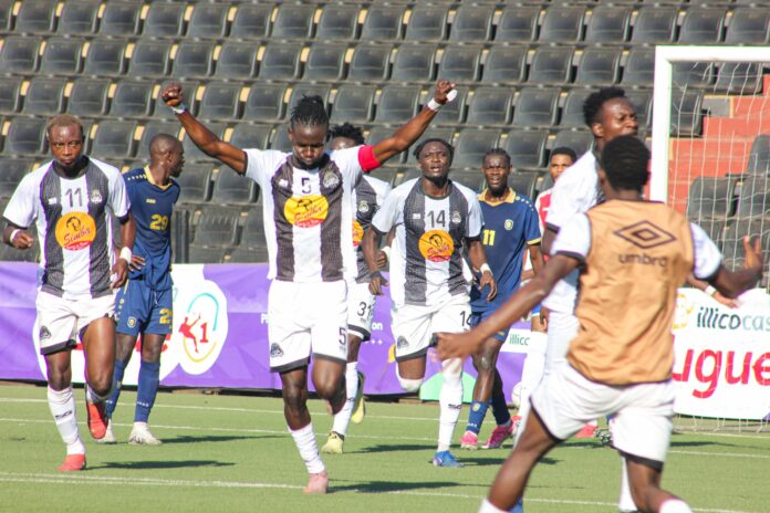 Joueurs de football en action sur le terrain du stade de Kamalondo