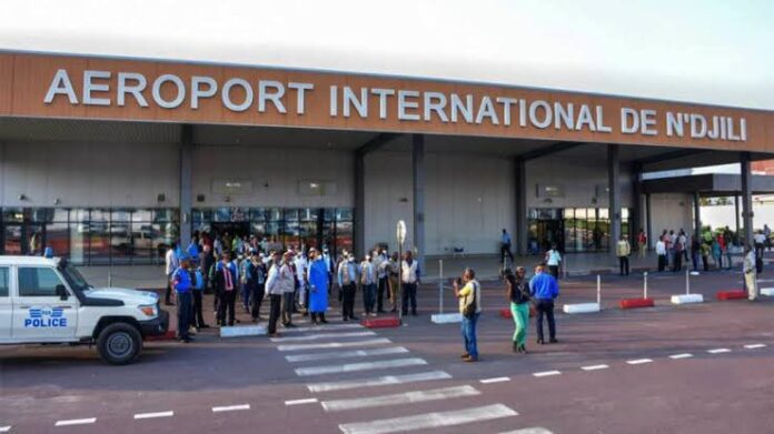 Femme colombienne à l'aéroport de Kinshasa avec des documents de voyage, attendant son vol de retour.