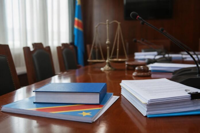 Salle institutionnelle congolaise avec documents juridiques posés sur une table de travail