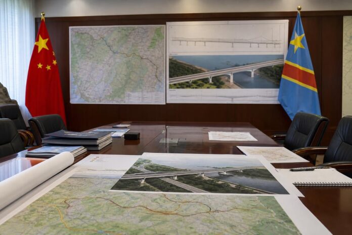 Signature de contrats de construction routière par le ministre John Banza Lunda à Kinshasa, avec documents et plans d'infrastructure