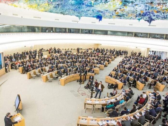 Salle de l'Assemblée du Palais des Nations à Genève avec des représentants internationaux
