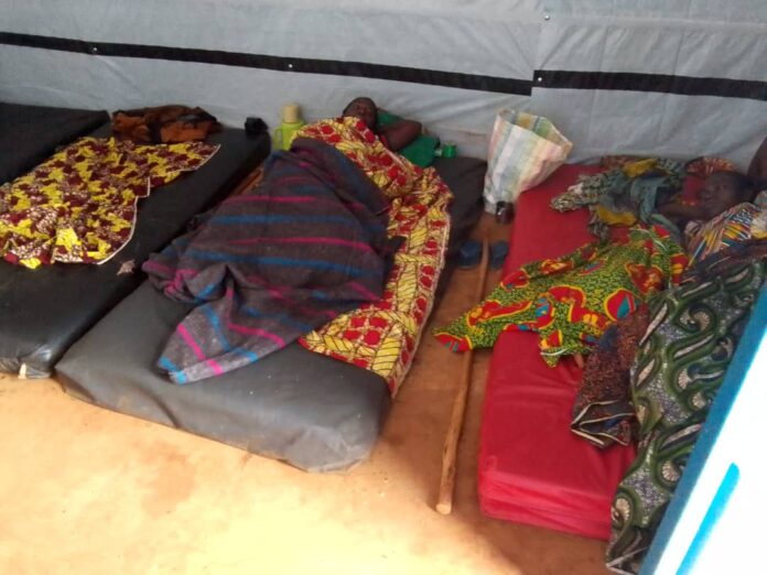 Batiment hospitalier de Kavumu avec cour sobre et sorties de service dans un contexte de crise sanitaire et sociale