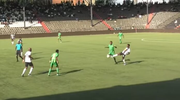 Stade Kamalondo bondé avec joueurs de TP Mazembe en blanc et Maniema Union en vert jaune sur le terrain