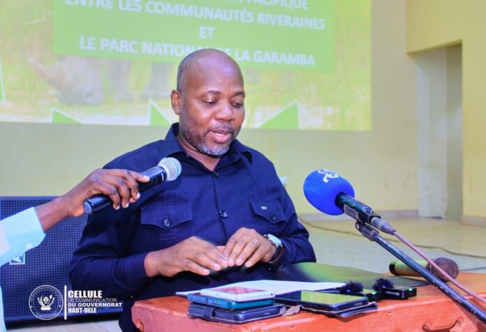 Route dégradée menant à Bogoro avec véhicules officiels et habitants rassemblés en bordure