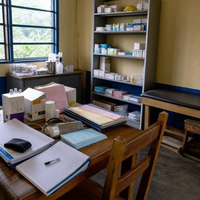 Carte de soins et registres medicaux poses sur une table dans un centre de sante a Kindu