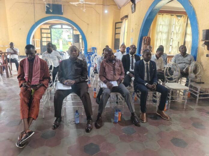 Salle de réunion à Kindu avec des documents de travail sur le SMIG, les contrats et la sécurité sociale des écoles privées