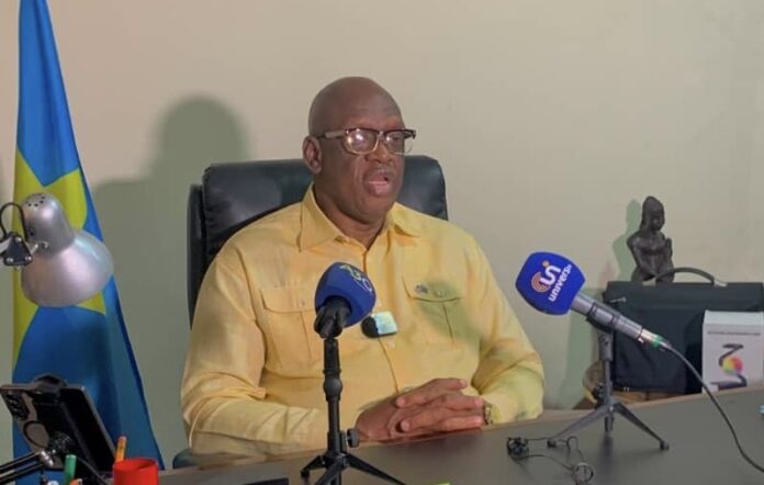Salle de conférence vide avec micros et drapeau congolais symbolisant un dialogue national