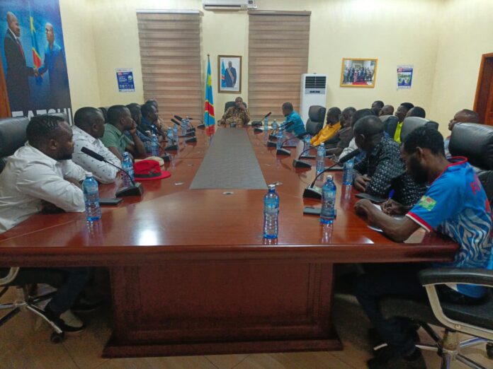 Gouverneur Jean Bakomito Gambu discutant avec des jeunes lors d'une réunion de sensibilisation contre Ebola au gouvernorat d'Isiro