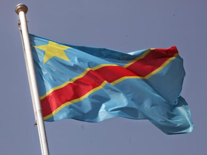 Drapeau congolais près d'un pupitre officiel lors d'une cérémonie patriotique sobre