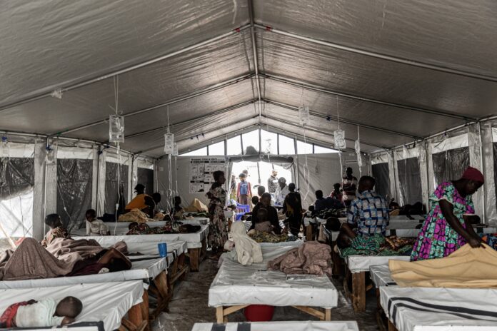 Centre de santé à Kabimba avec des lits et des équipements médicaux, bidons d'eau chlorée