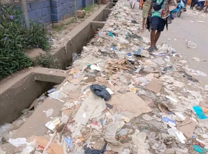Dépotoir sauvage le long d'une artère principale à Kindu avec des déchets ménagers accumulés