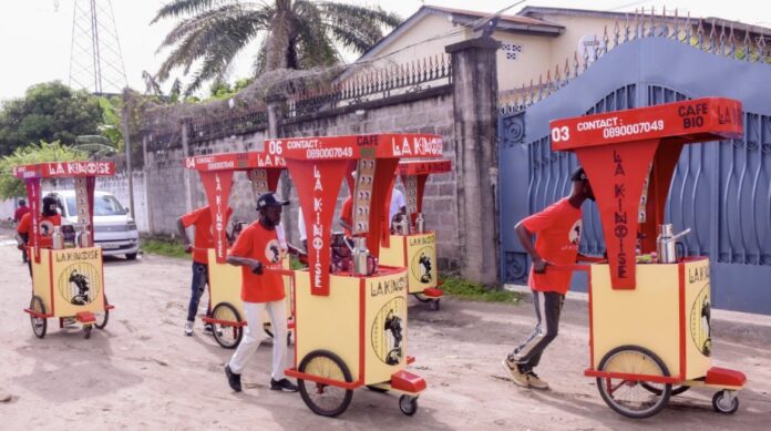 Vendeur ambulant servant du café chaud sur un chariot dans une rue de Kinshasa