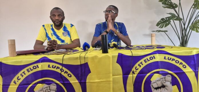 Salle de réunion avec le logo du FC Saint-Éloi Lupopo et des documents de transfert