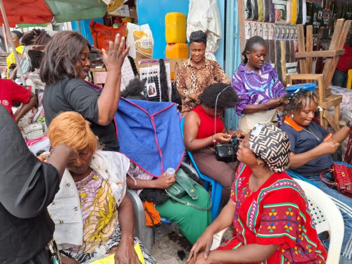 Salon de coiffure à Mbuji-Mayi avec clientes attendant des tresses