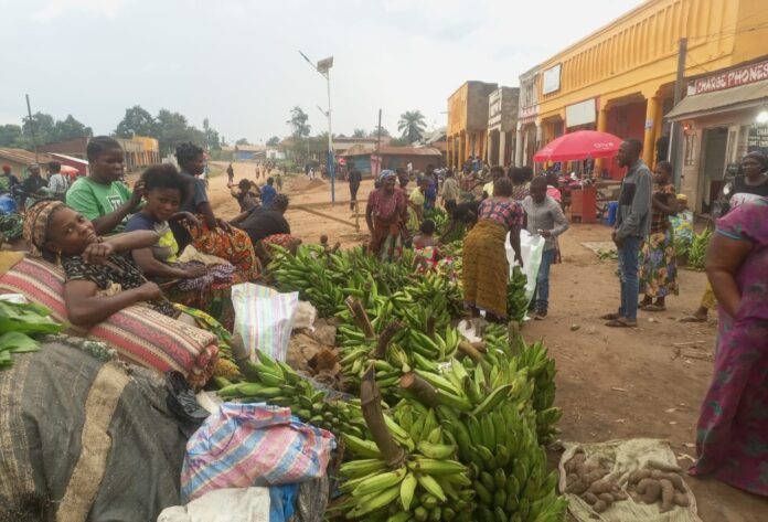 Barrière à la frontière entre la RDC et l'Ouganda, panneau d'avertissement Ebola et véhicules à l'arrêt