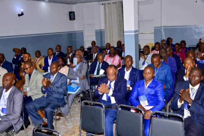Salle de séminaire avec tables, chaises et un podium dans un site touristique de Kinshasa