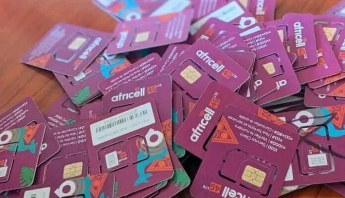 Étalage de cartes de recharge téléphonique dans un kiosque à Beni, avec les couleurs des opérateurs Airtel, Vodacom et Orange