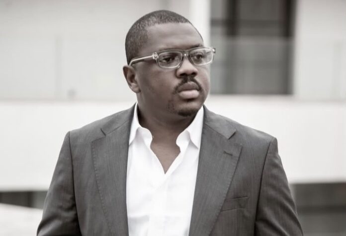 Pupitre avec micros et drapeaux dans une salle de conference, evoquant un point de presse politique sur le dialogue national en RDC