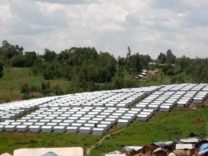 Camp de déplacés surpeuplé en RDC avec des abris de fortune et des familles