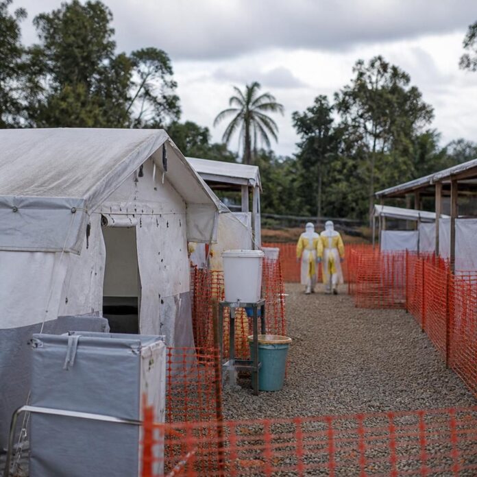 Centre de traitement Ebola avec tentes blanches et barrières de sécurité dans une zone rurale en Ituri