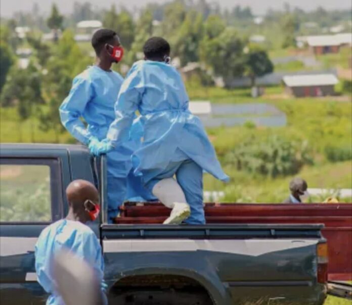 Ambulance endommagée et personnel de santé en tenue de protection près d'un centre de traitement Ebola en RD Congo