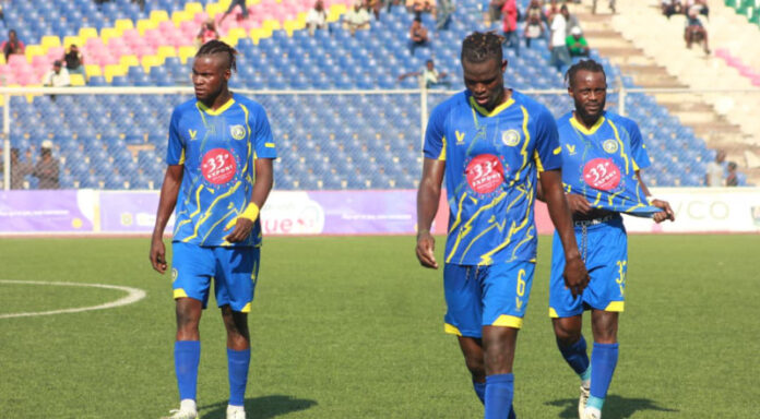 Joueurs de football en tenue jaune et bleue sur un terrain, symbolisant les recrues du FC Lupopo