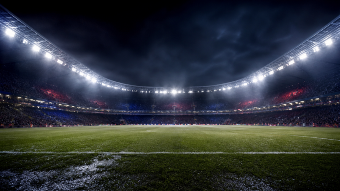 Illustration editoriale neutre d un stade francais de nuit apres le nul 2-2 entre Rennes et le PSG avec une fin de match tendue.