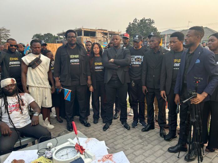 Bougies allumées et croix en bois sur un espace vert lors d'une commémoration à Kinshasa