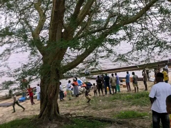 Pirogue en bois chargée de colis sur une rivière agitée près d'Isangi, au moment du chavirement