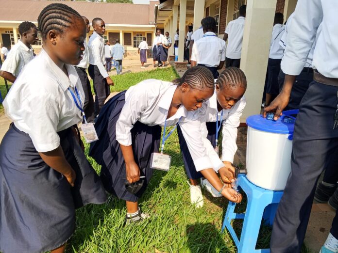 Écoliers se lavant les mains devant une école en Ituri pendant l'épidémie d'Ebola