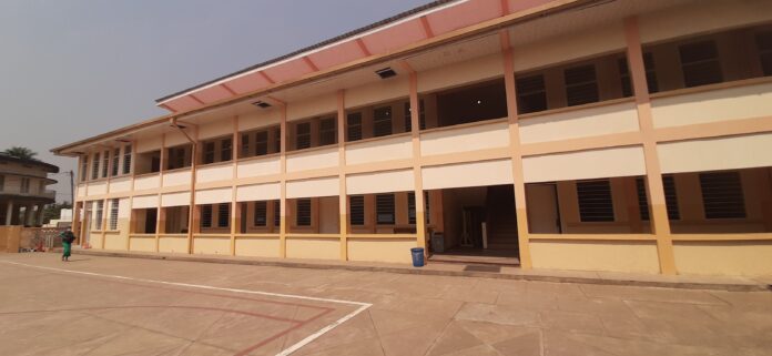 Vue d'un bâtiment scolaire rénové avec des salles de classe et une cour dans un complexe éducatif