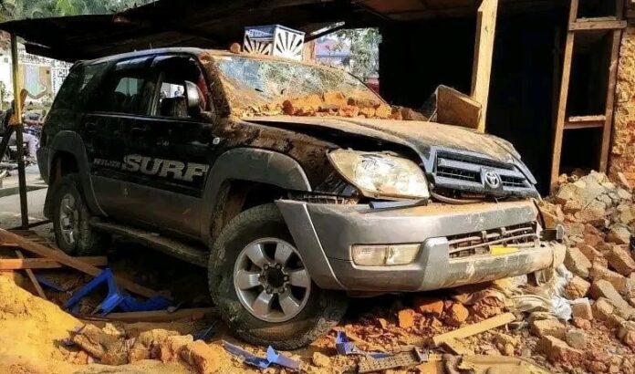 Véhicules accidentés sur une avenue à Kindu, l'un encastré dans une boutique, des curieux et des secouristes autour