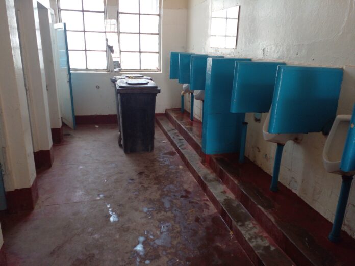 Rue animée de Kinshasa sans toilettes publiques, avec des passants et des étals