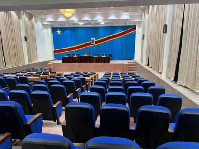 Salle de réunion vide dans une localité du Kasaï-Central, symbolisant l'absence des élus