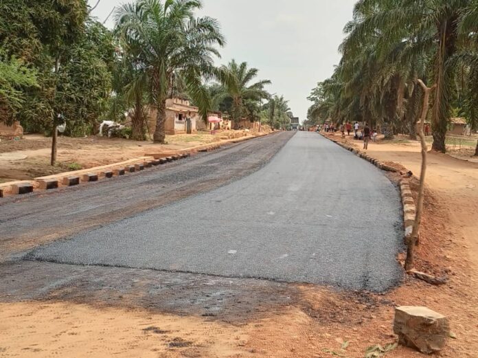 Engins de chantier sur une route de Lusambo en terre battue, en vue de l'asphaltage
