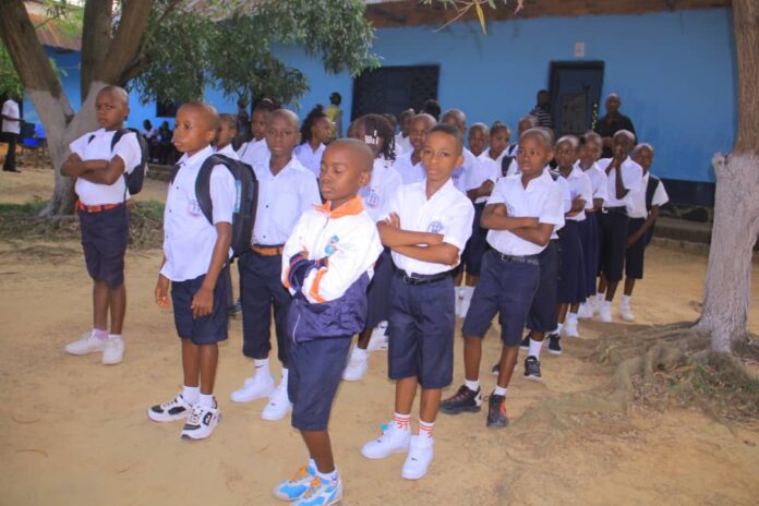Salle de classe équipée de bancs, de livres et d'un tableau au Complexe scolaire Mapon