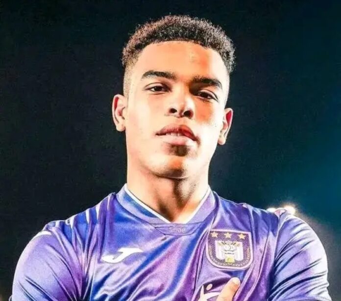 Jeune footballeur en tenue sportive, ballon au pied, sur un terrain d'entraînement en Allemagne, évoquant son possible transfert